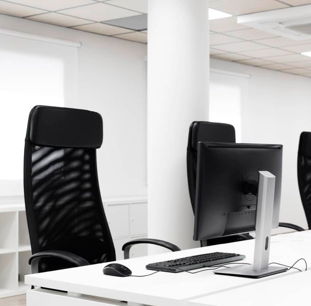 Open plan office workstations with monitors and task chairs.