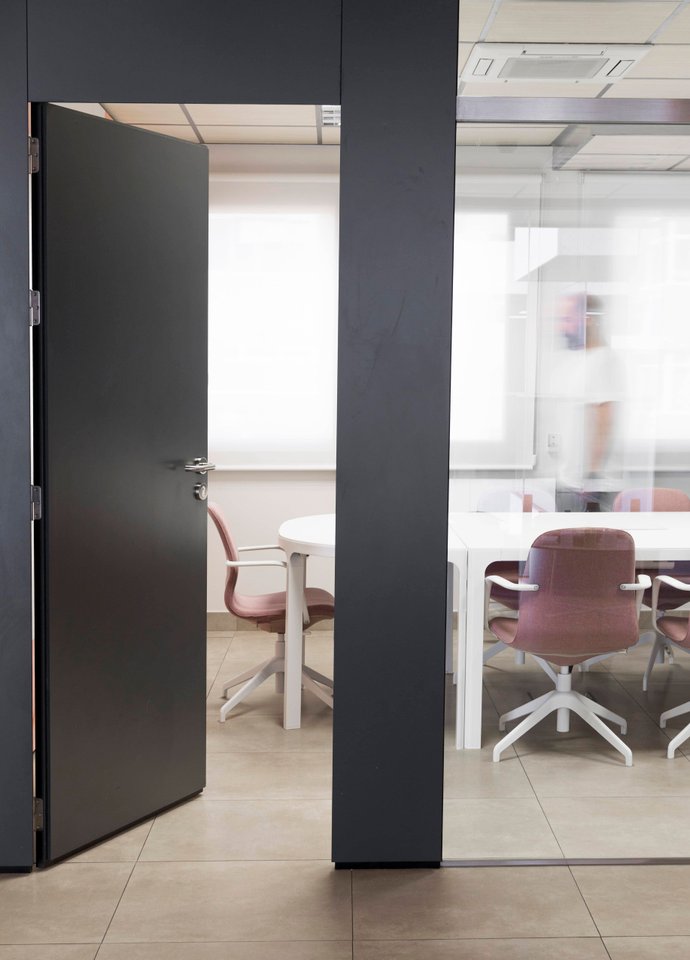 Modern commercial office interior with glazed meeting rooms.